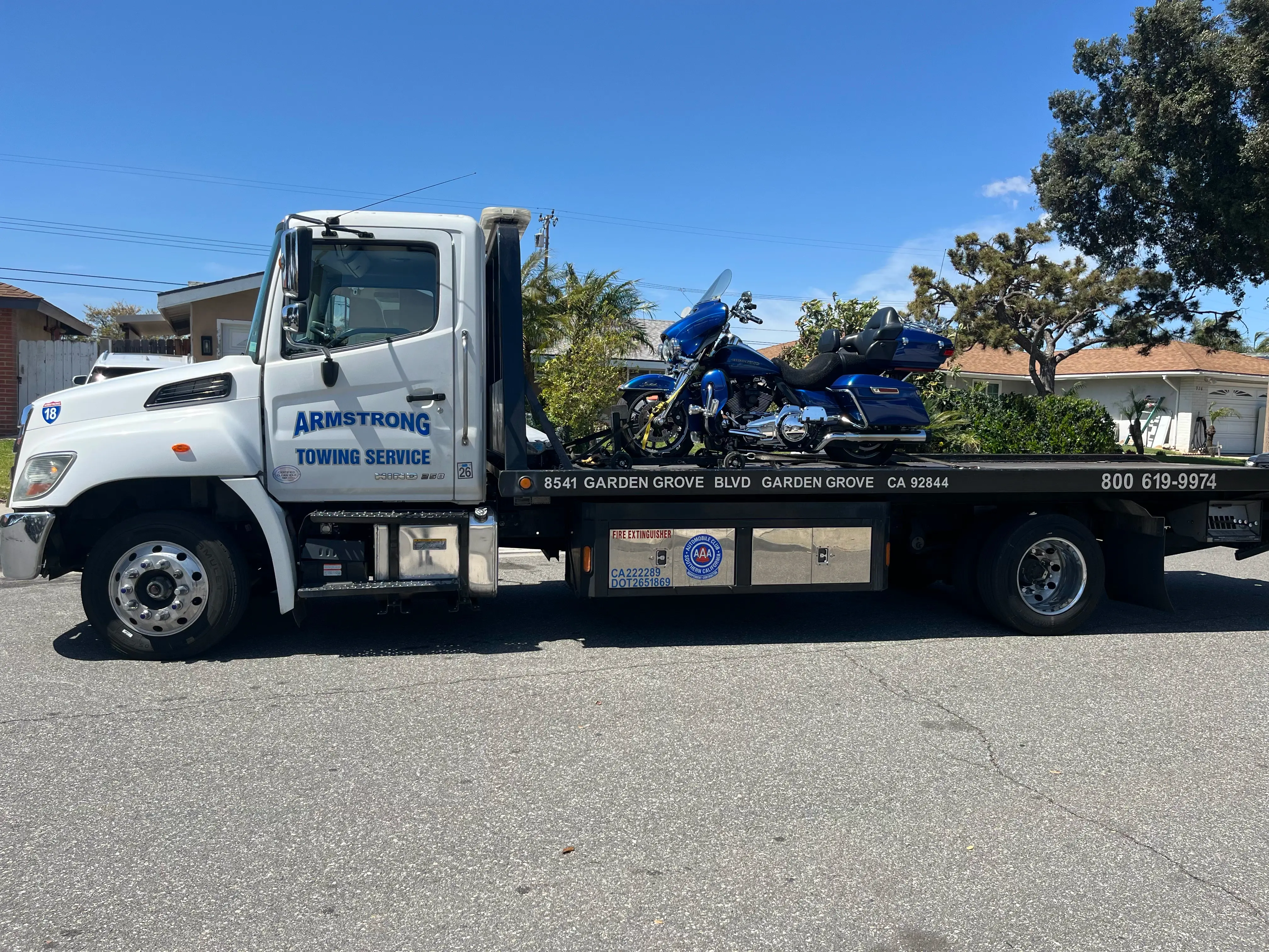 Flatbed tow truck lifting a luxury motorcycle