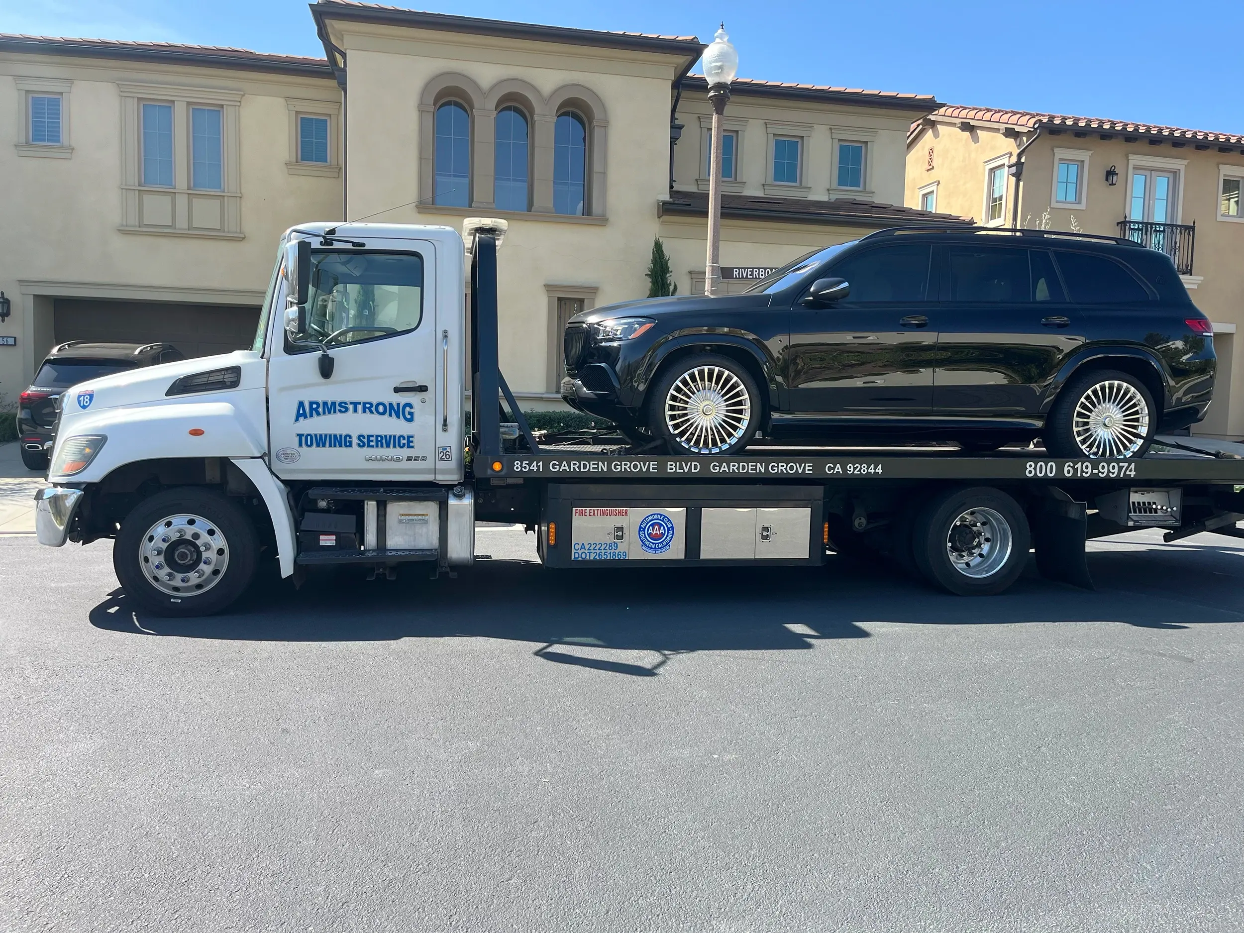 Wheel lift tow truck preparing for vehicle pickup